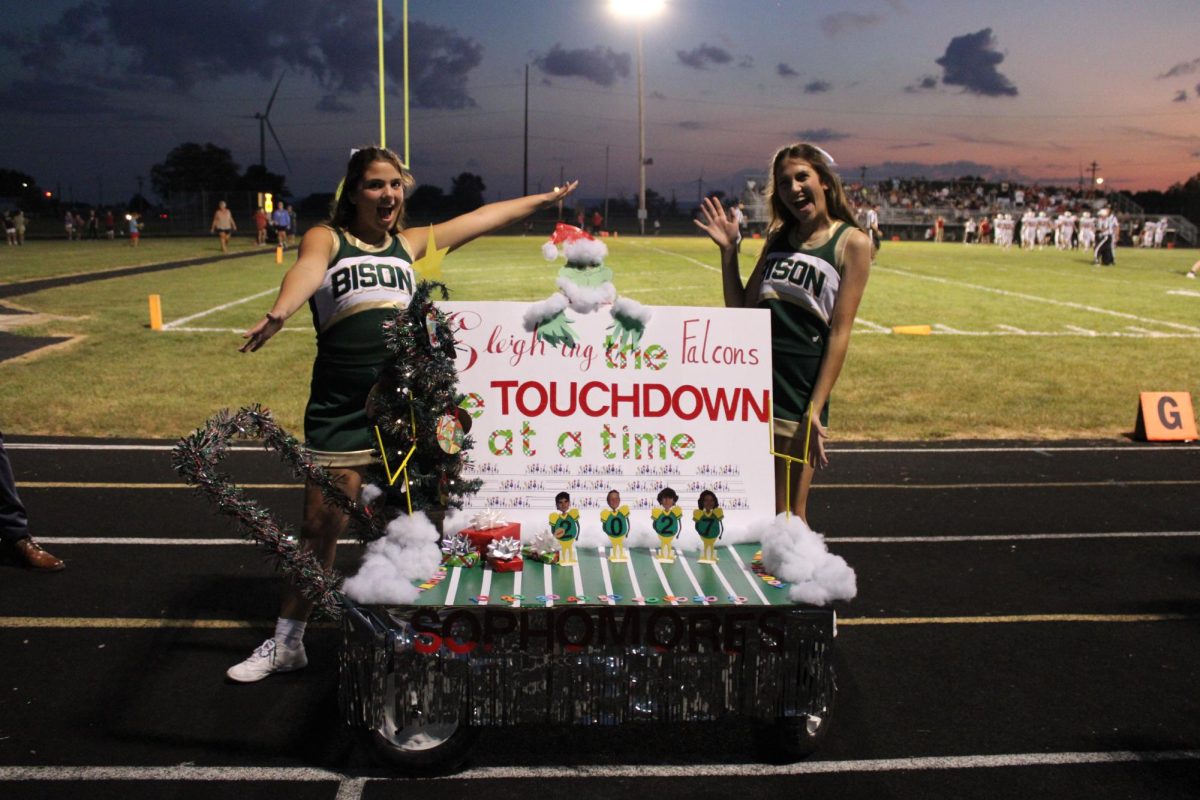 Sophomores Keely Watt and Aubree Reed pose with their "Grinch" themed class cart. 