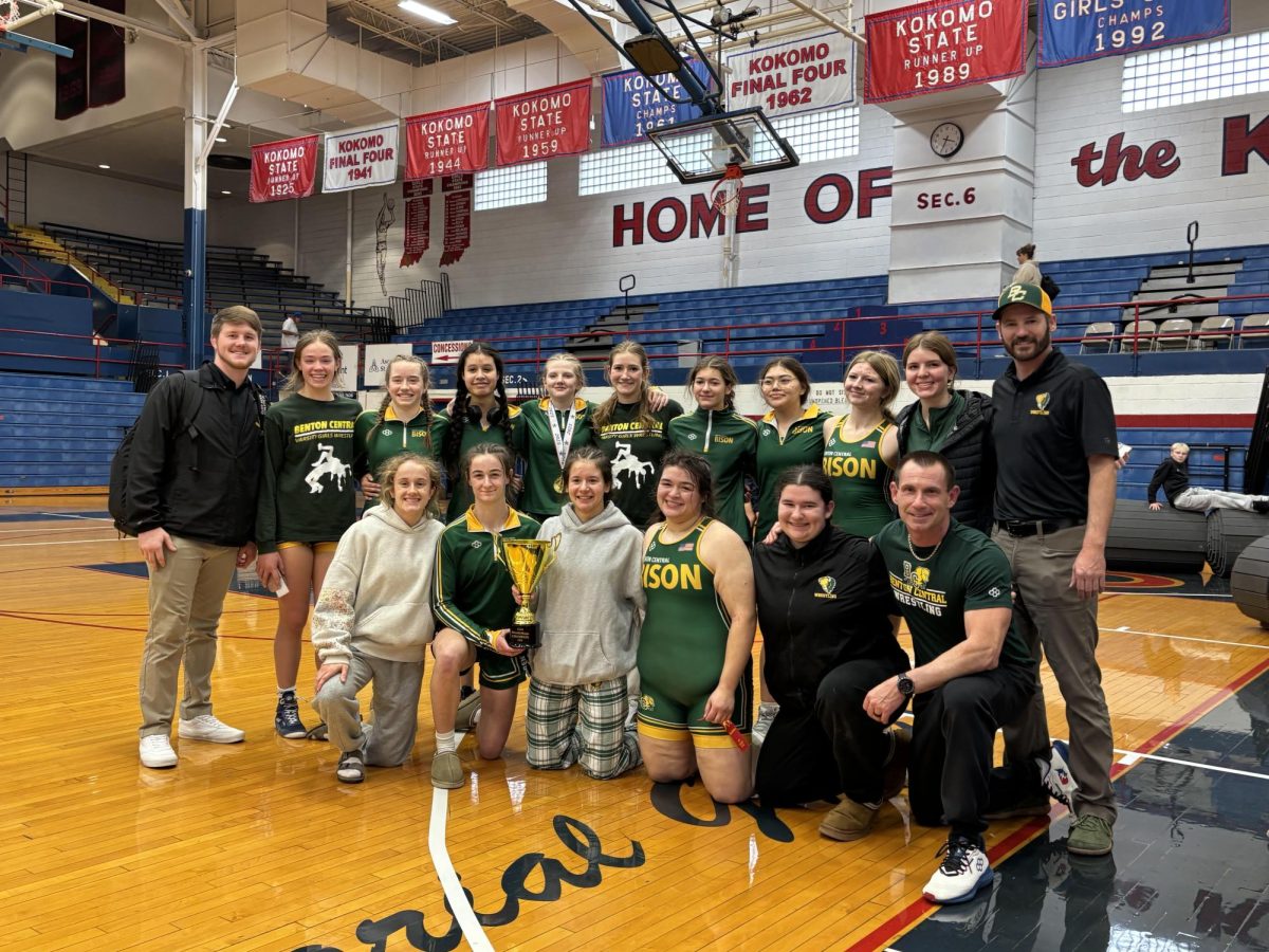 the women's wrestling team posing with there trophy.